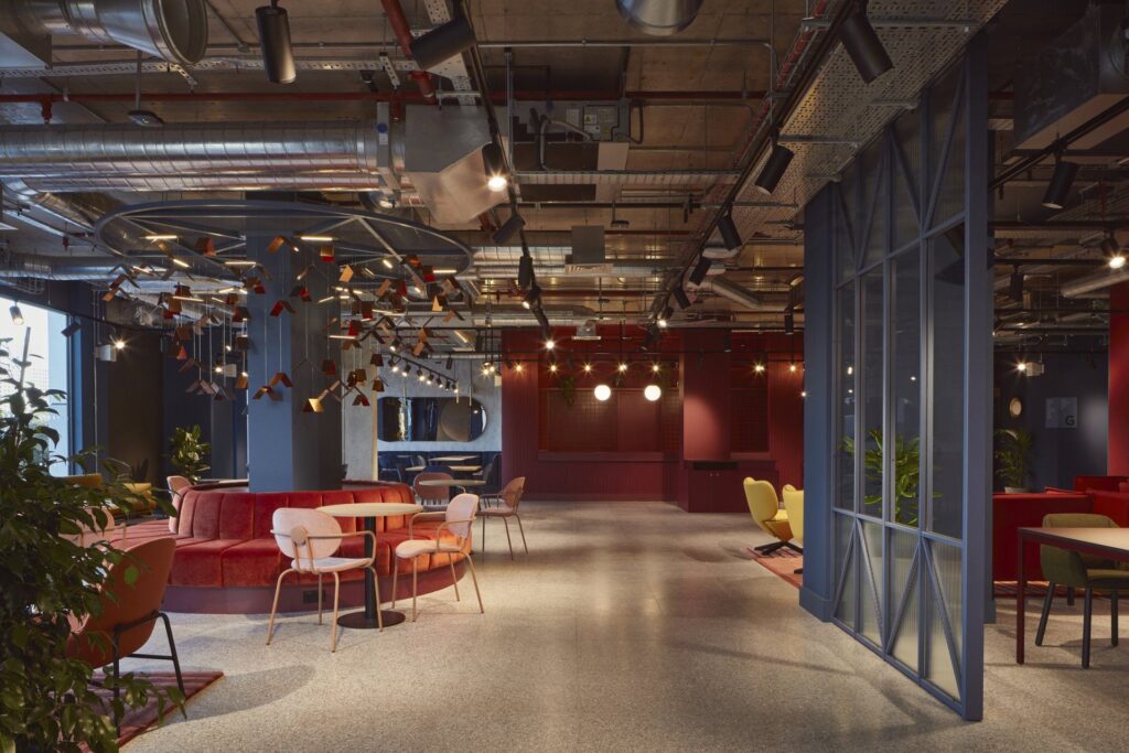 211111_workspace_mirrorworks_trifle_selects_001-1920w.JPG Modern open office space with colorful seating, exposed ceilings, and contemporary lighting.