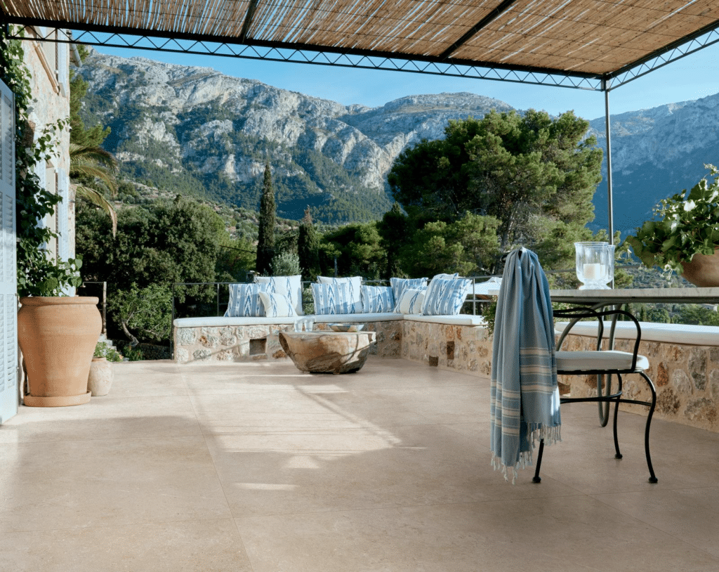 Outdoor patio with a tiled floor, mountain view, and seating area under a pergola.