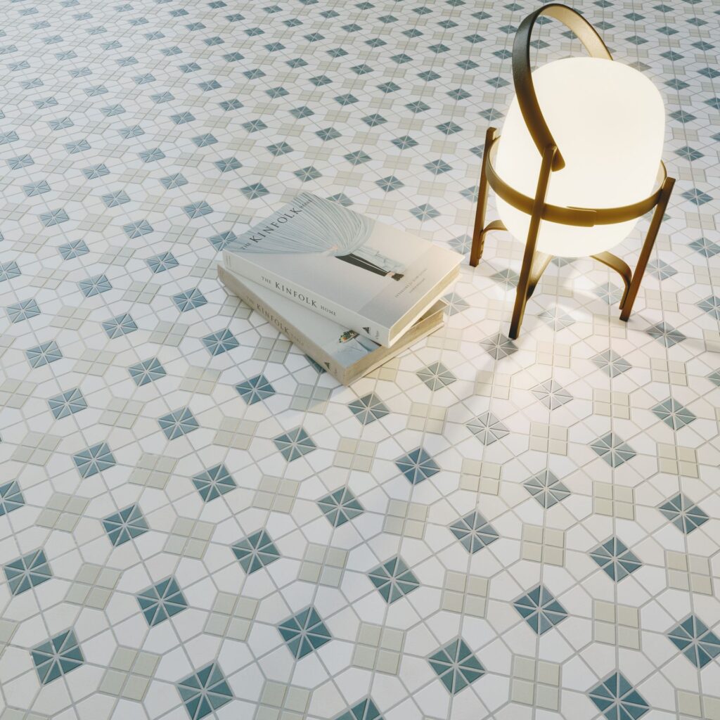 A lamp and two books on patterned tile floor.