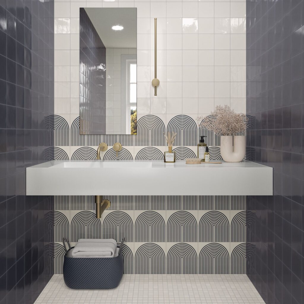 Modern bathroom with geometric wall tiles, a white sink, mirror, and decorative items on the counter.