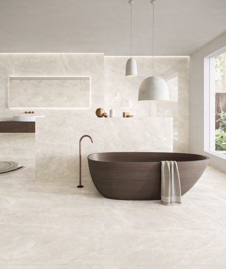 Modern bathroom with a dark oval bathtub, white walls, and large windows letting in natural light.
