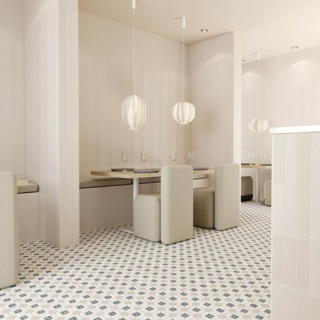 04-14489de2-1920w.jpeg Modern cafe interior with white booths, pendant lights, and patterned tile flooring.
