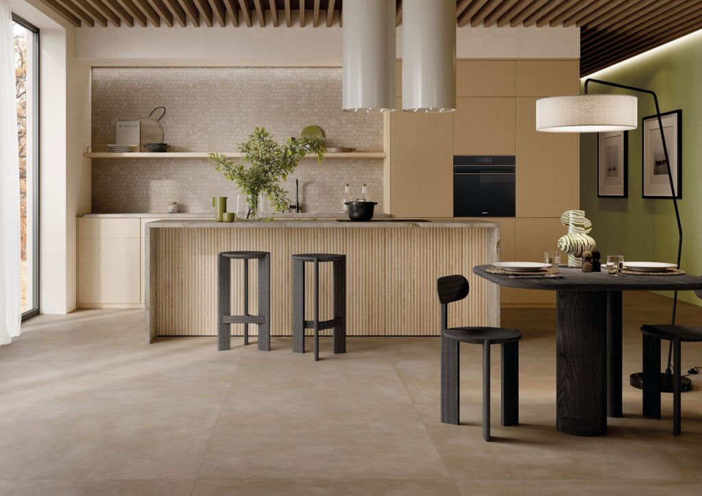 AMB_BEIGE_2_HD-1920w.jpg Modern kitchen with beige cabinets, island, round table, and black stools. Minimalist decor and lighting.