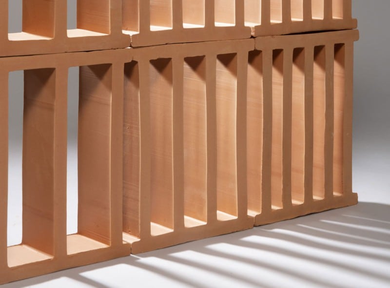 Terracotta blocks with vertical openings, stacked to form a divider.