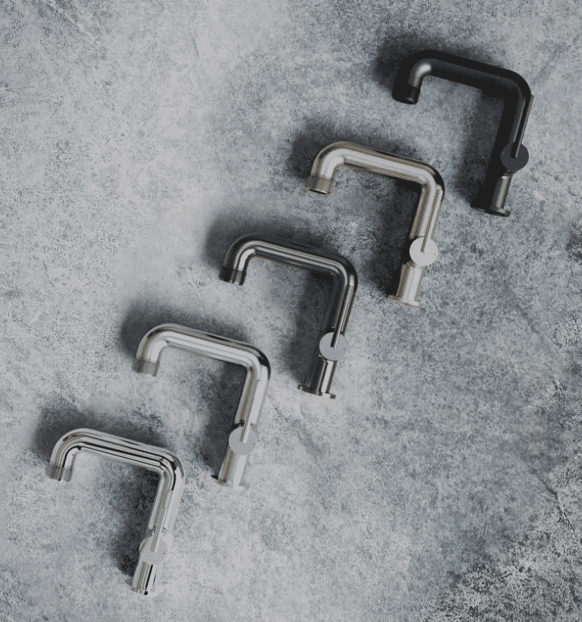 Five modern faucets in different finishes arranged diagonally on a textured gray surface.