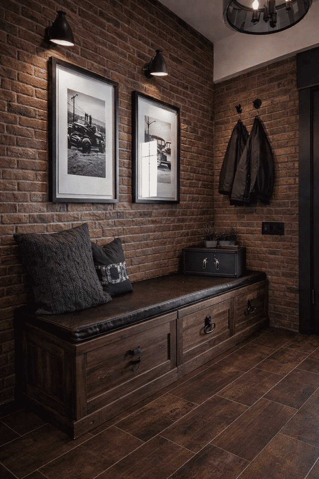 Cozy industrial nook with brick walls, framed photos, a bench, pillows, and jackets hanging on hooks.