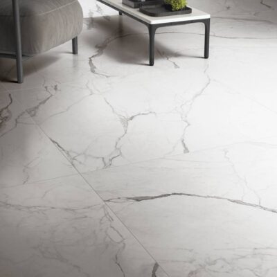 White marble floor tiles with gray veining, a chair, and a coffee table in a modern room.