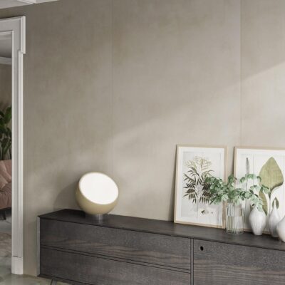 Modern console table with a round lamp, framed art, and vases against a beige wall.