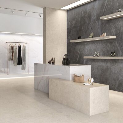 Modern retail store with clothing, handbags, and shoes displayed on shelves and racks.