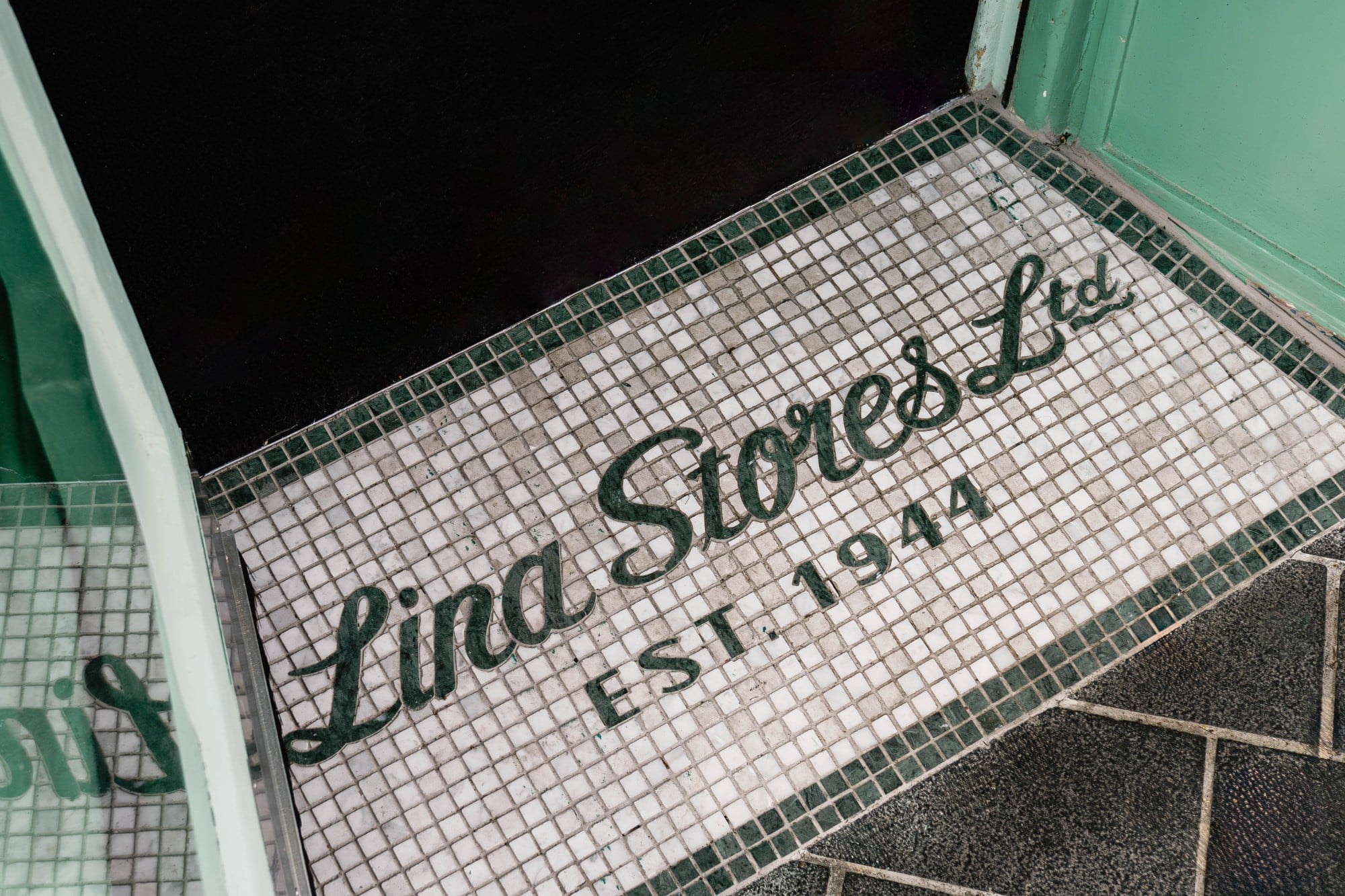 Mosaic entrance sign reading "Lina Stores Ltd. Est. 1944" at a doorway.