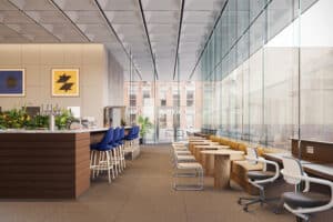 Modern coffee bar with stools and tables next to large windows in a bright, open space.