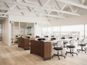 Modern office space with white chairs, wooden desks, and large windows.