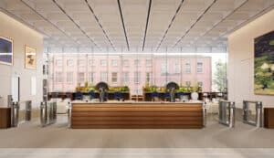 A modern, spacious building lobby with a wooden reception desk and large windows.