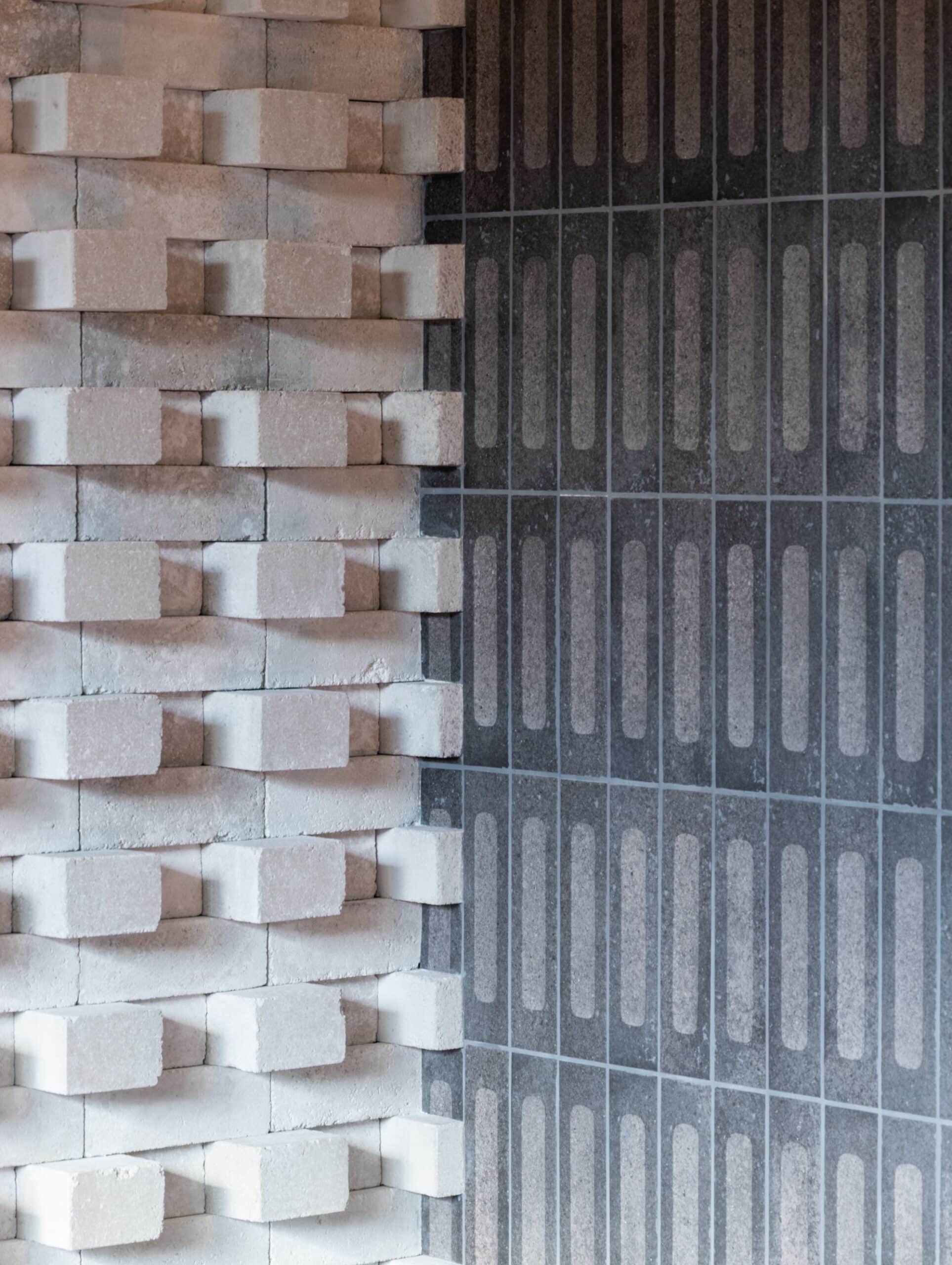 White textured bricks next to a dark, patterned tiled wall.