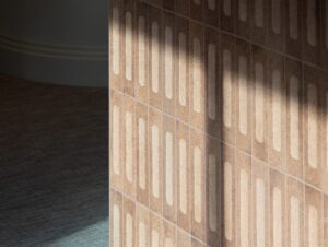 Sunlight casts a shadow on a brown tiled wall with a geometric pattern.